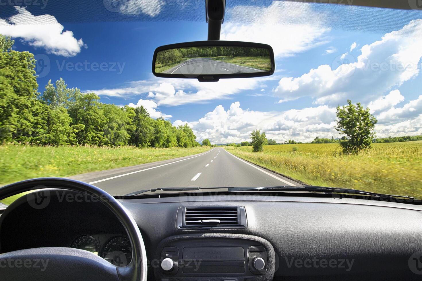 A view of a car driving down a road with a view of the sky photo
