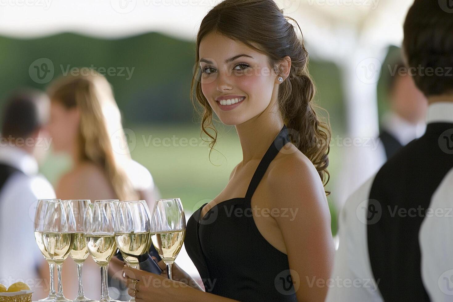 A woman in a black dress holding a tray of wine glasses photo