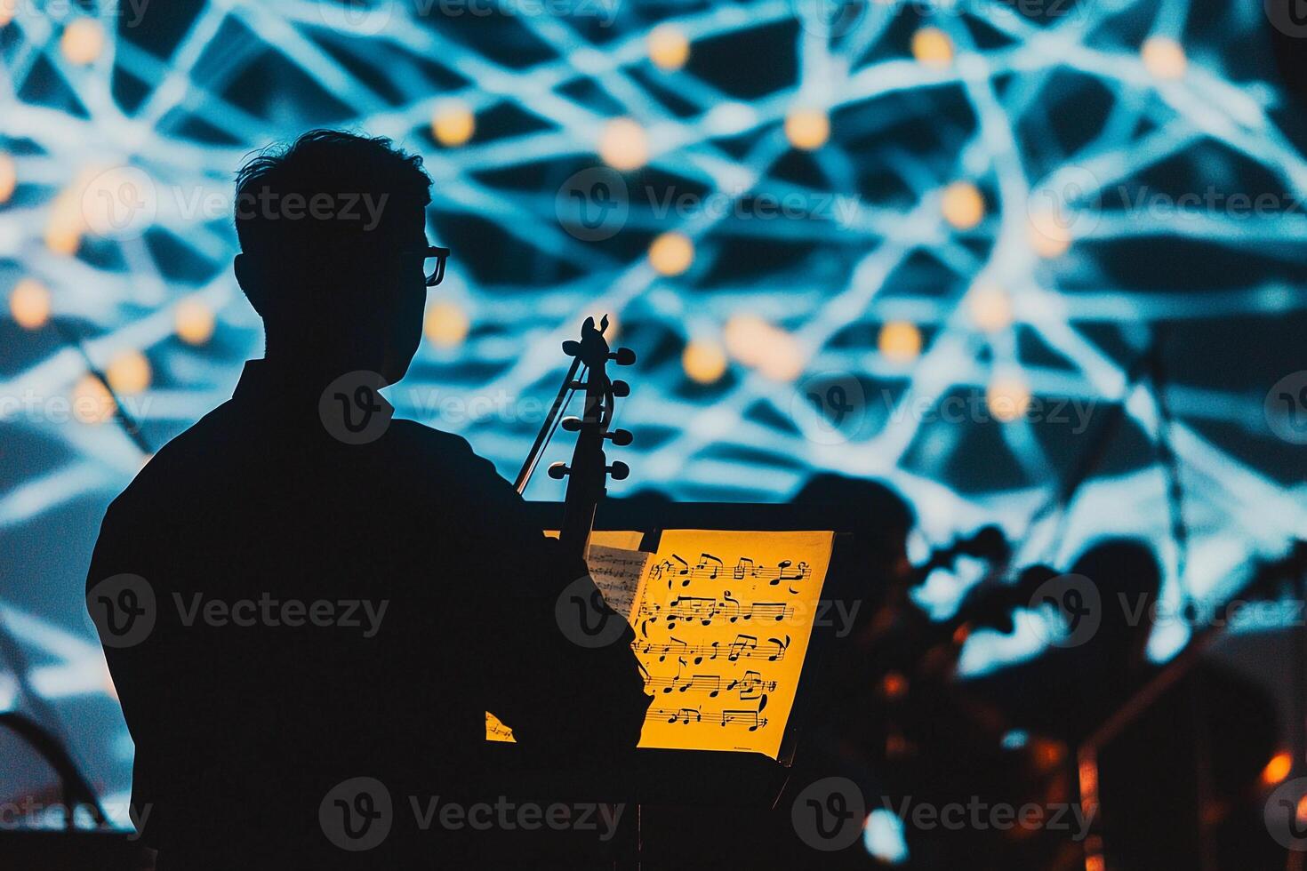 A man playing the violin in front of a large screen photo
