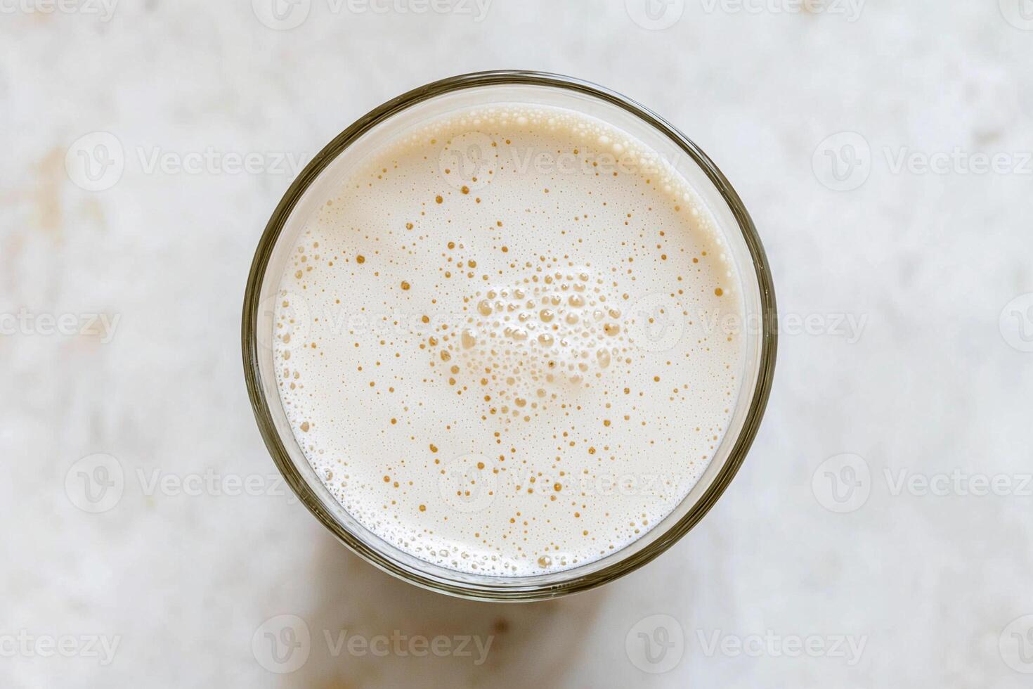 A glass of milk sitting on a marble surface photo