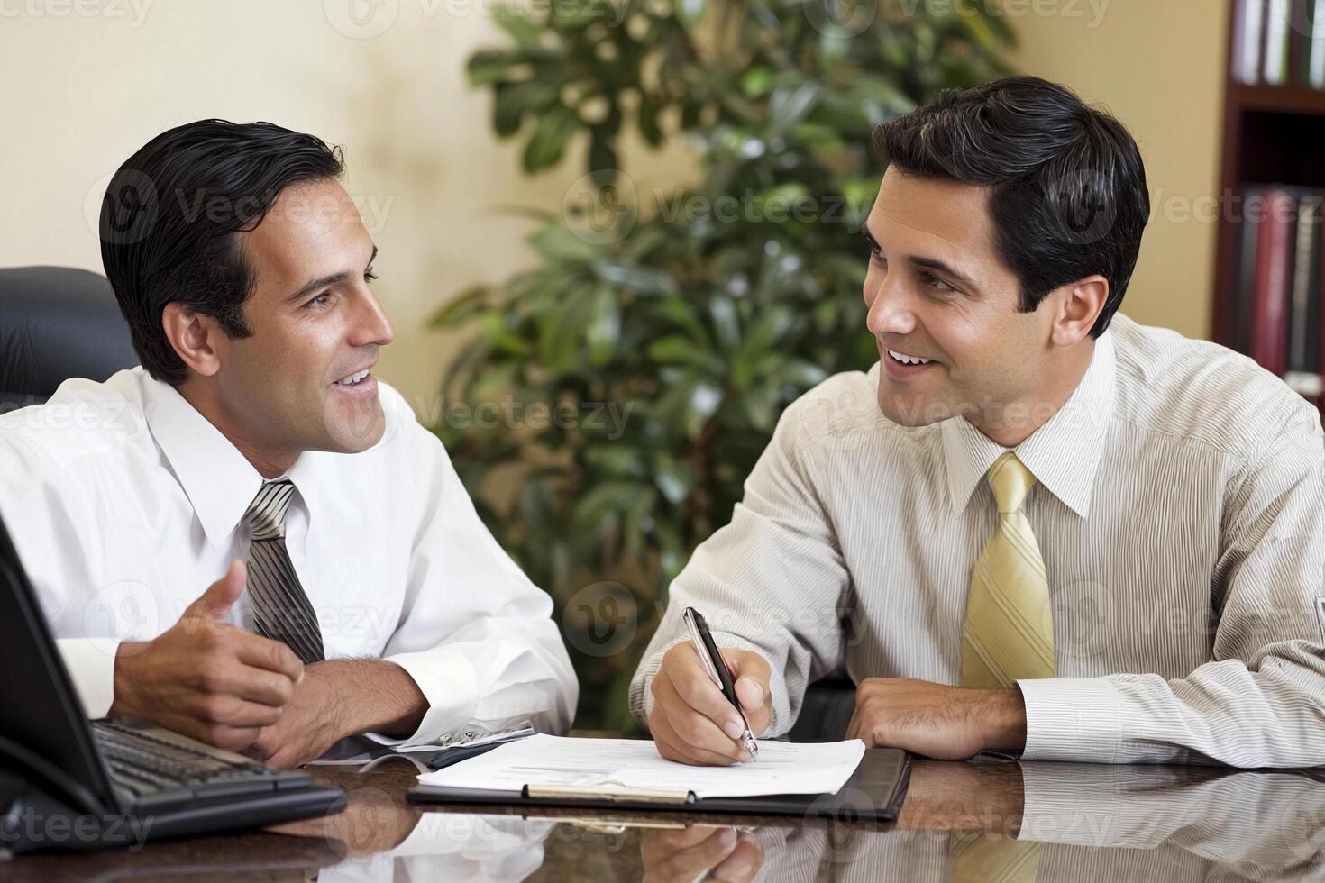 Two men in business attire sitting at a desk photo