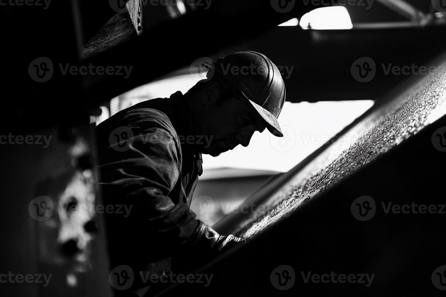 A man in a hard hat is working on a metal structure photo