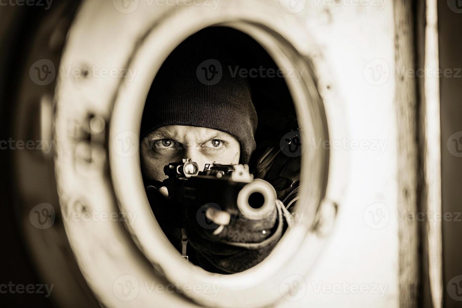 A man in a black jacket and hat is looking through a window photo