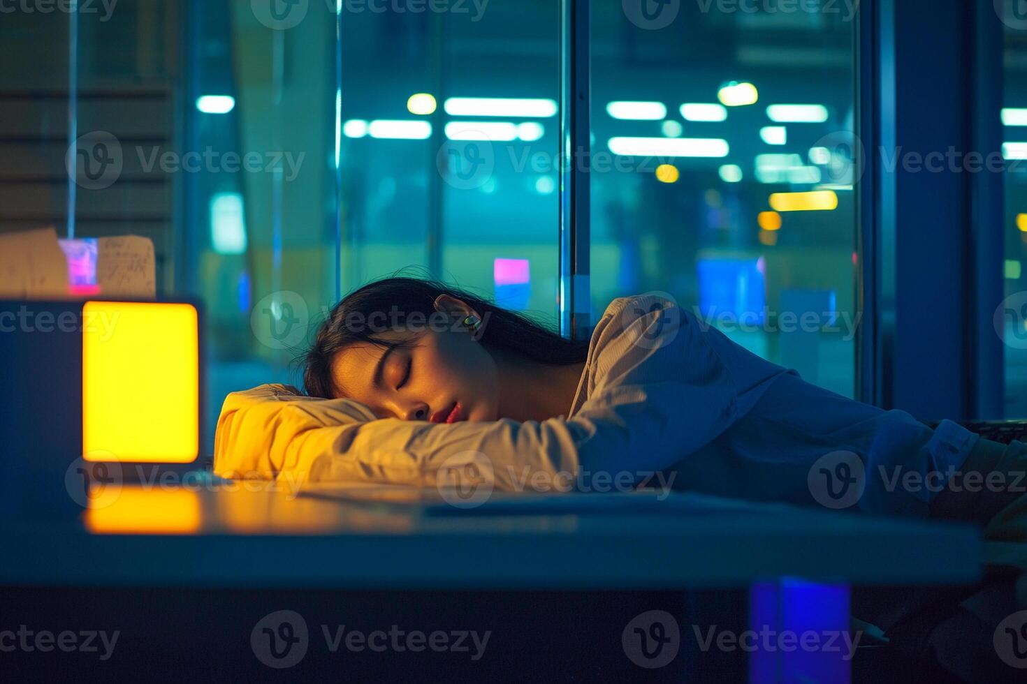 A woman sleeping on a table in front of a window photo