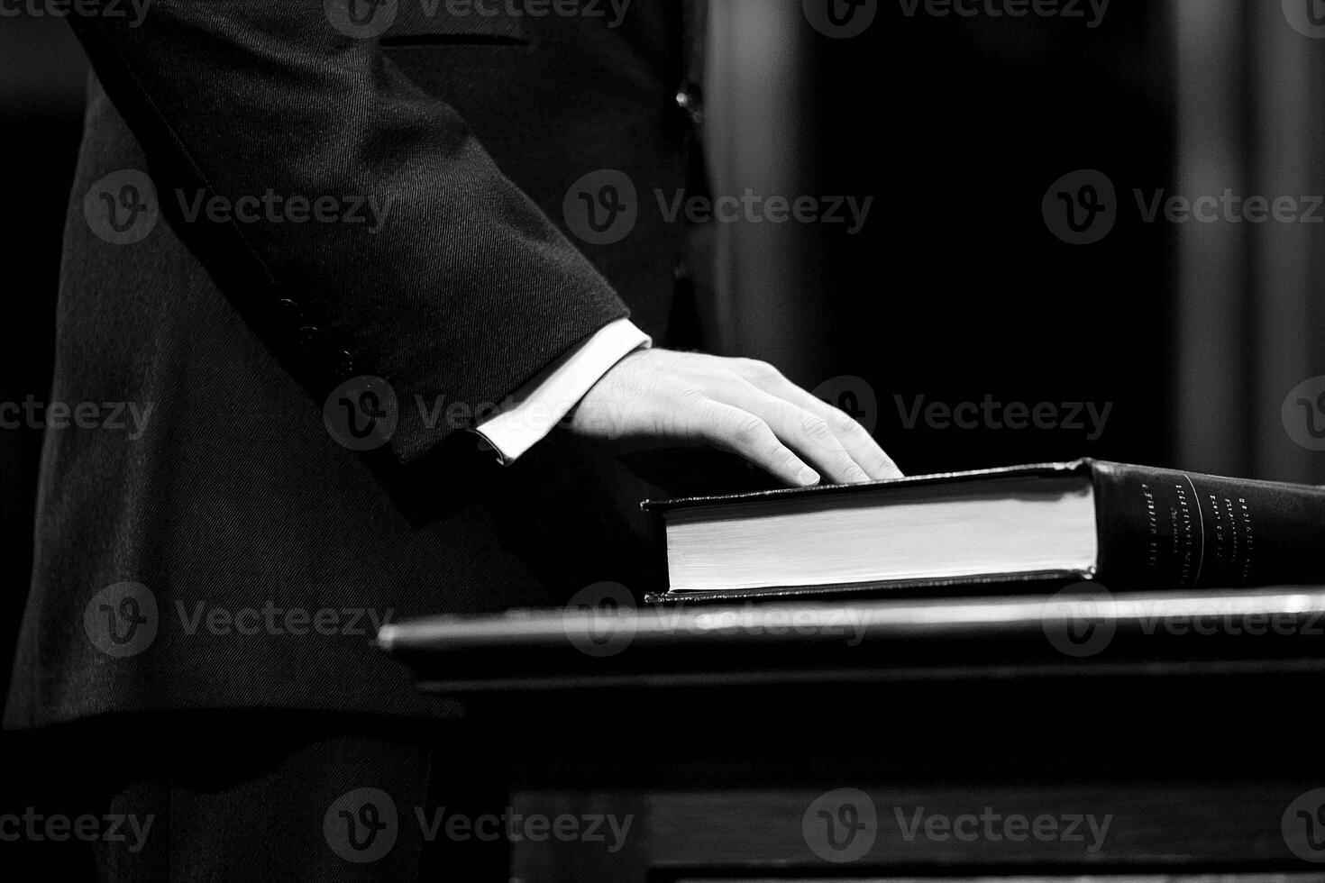 A man in a suit is holding a bible photo