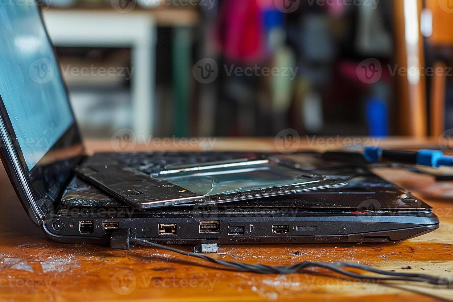 A laptop computer with a broken screen sitting on a table photo