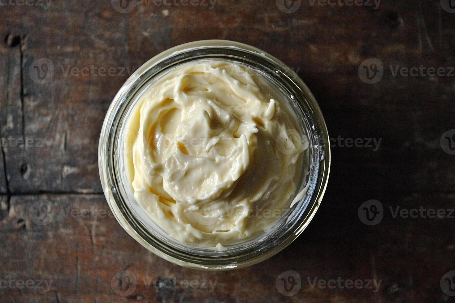 A jar of cream sitting on top of a wooden table photo