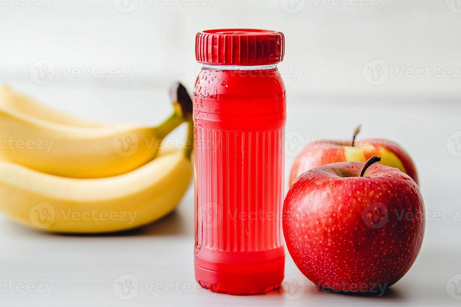 A bottle of water next to a banana and an apple photo