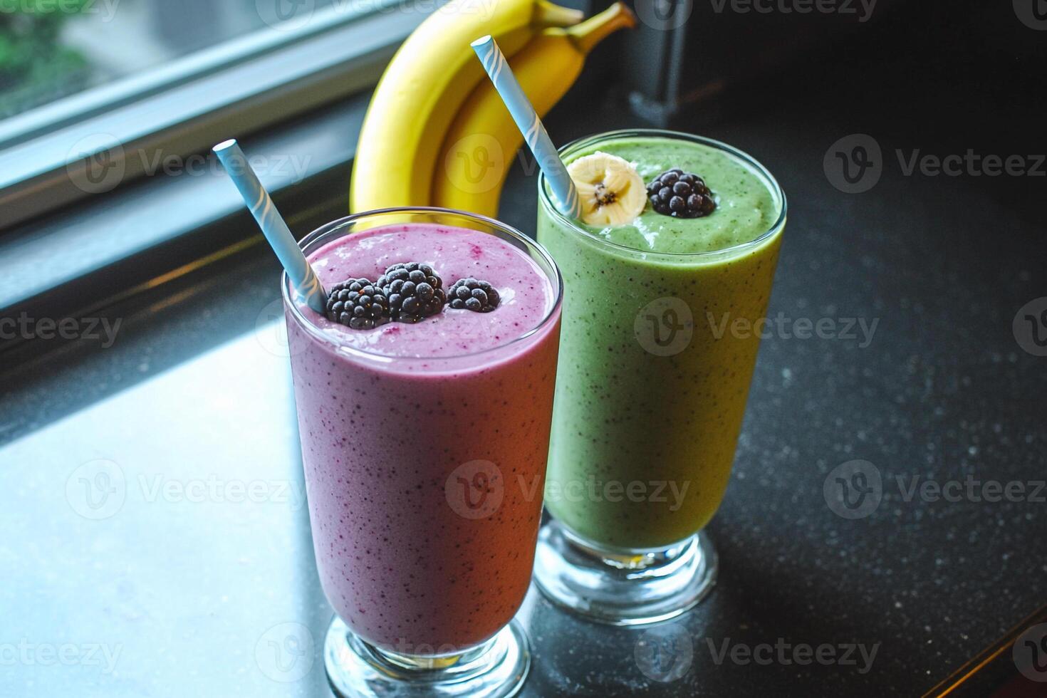 Two smoothies sit on a counter next to a banana photo
