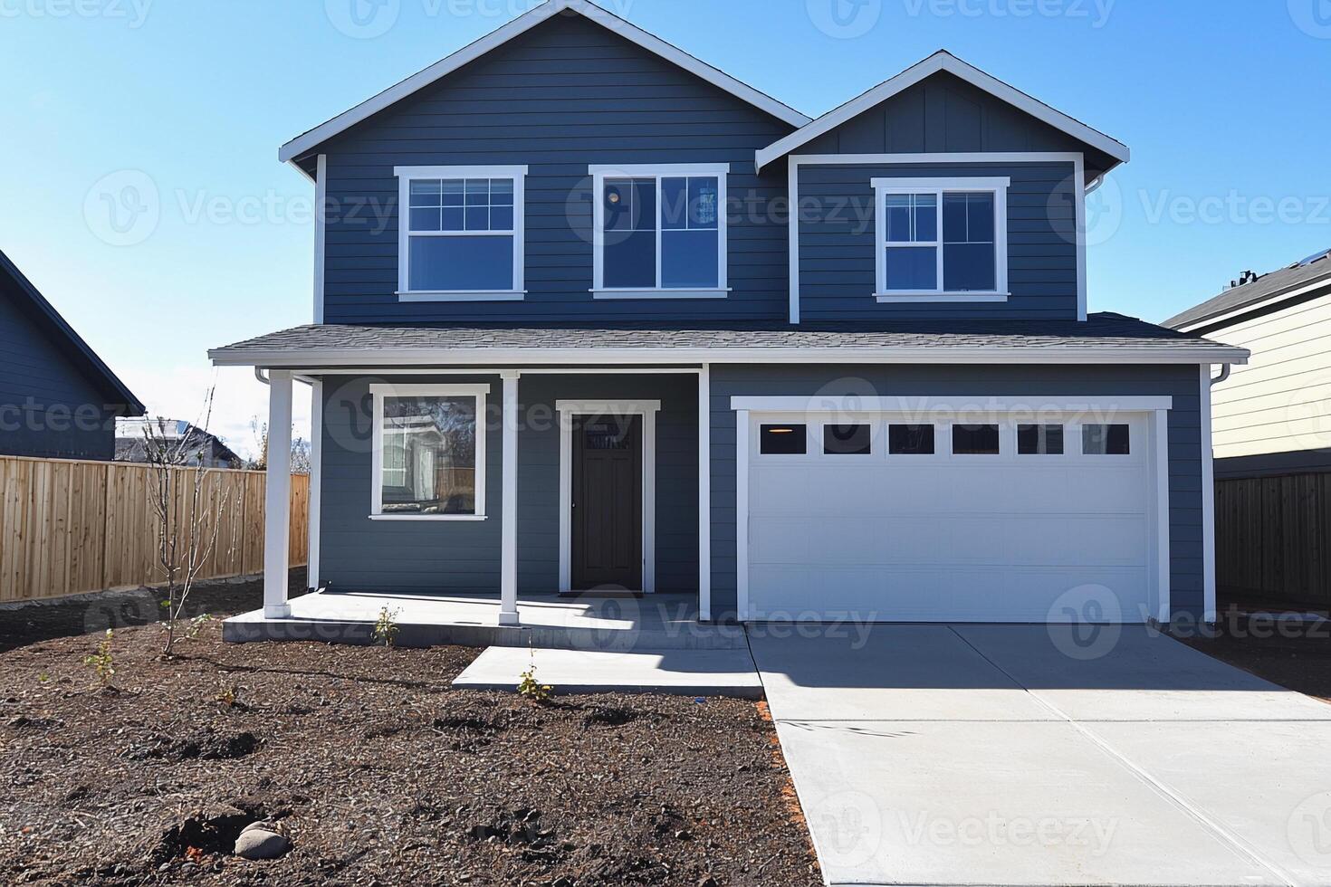 A gray house with a garage and a driveway photo