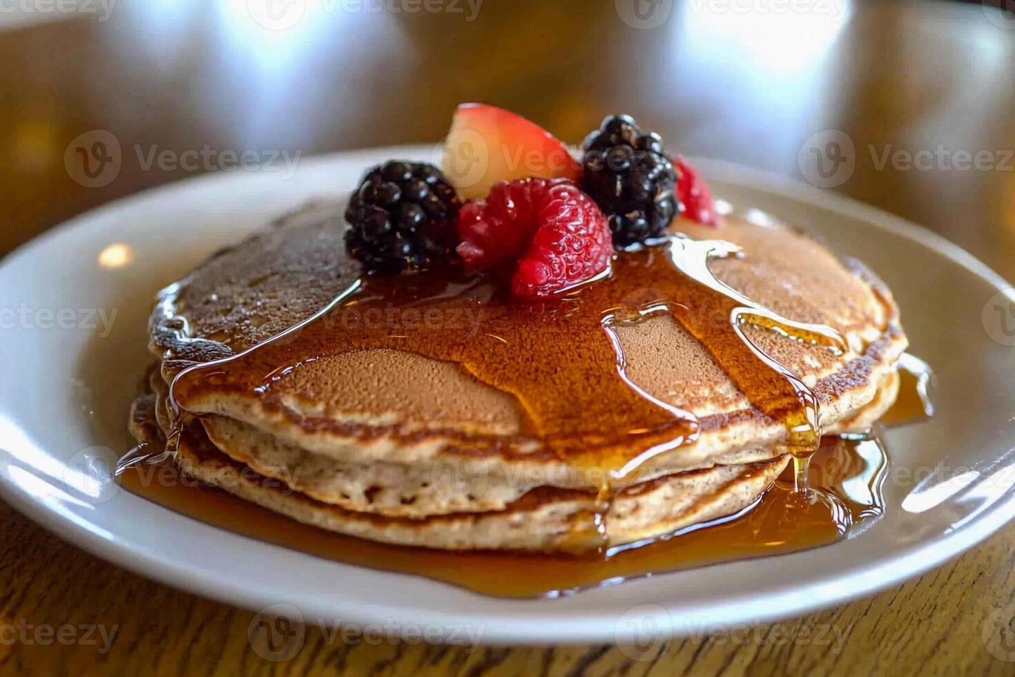 A stack of pancakes with syrup and berries on top photo