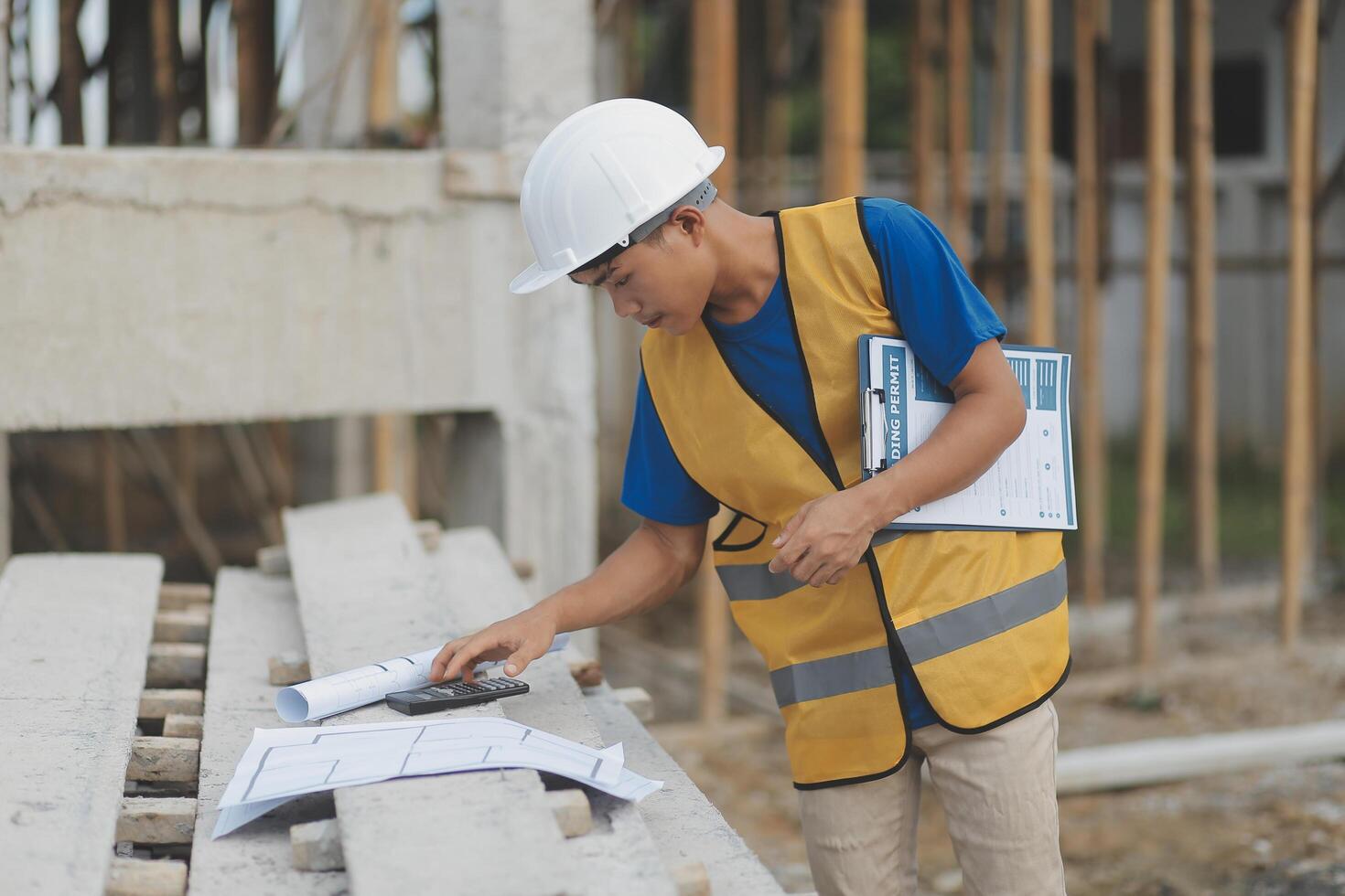 Young handsome asian civil engineer holding tablet looking forward and thinking, planning on construction building background. Evolution construction concept. photo