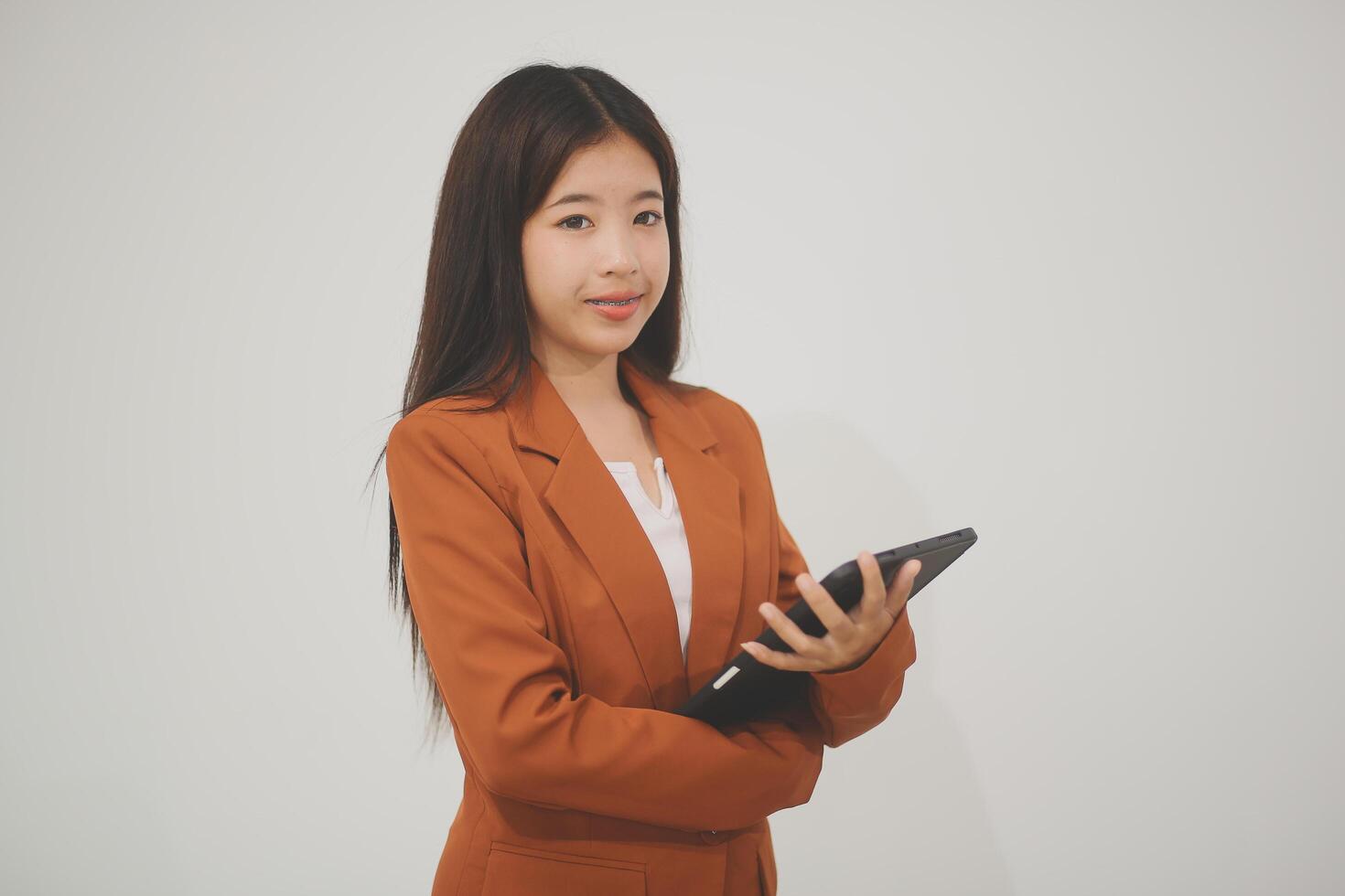 Young beautiful Asian woman in business office standing use tablet in hand, Thai girl enjoy browsing for online shopping store with copy space for advertisement, on isolated white background photo