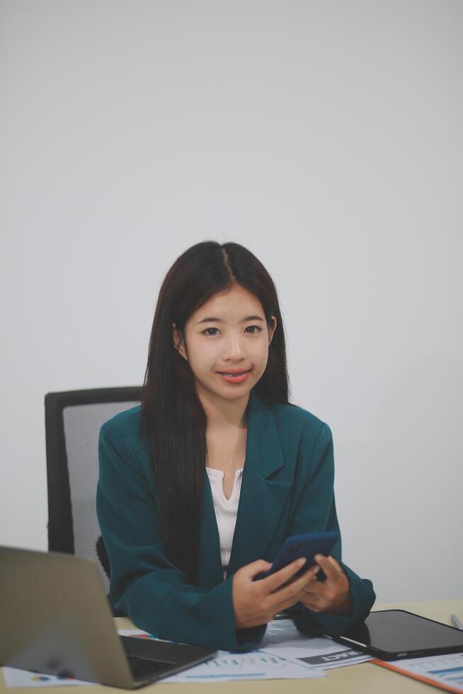 Attractive asian woman using a laptop PC and a smart phone. photo