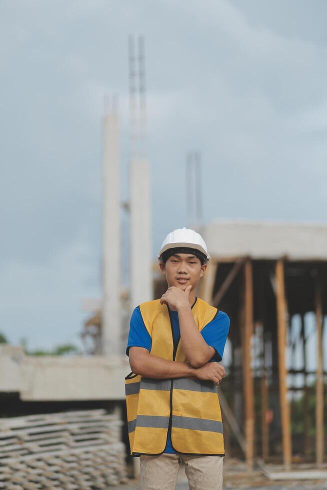 Asian man architect holds blueprint with skyscraper background, Asian male architect builder engineer design working planning confident outdoors in construction site. photo