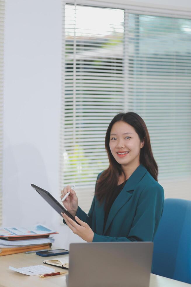 Asian professional businesswoman working on tablet computer in a corporate office photo