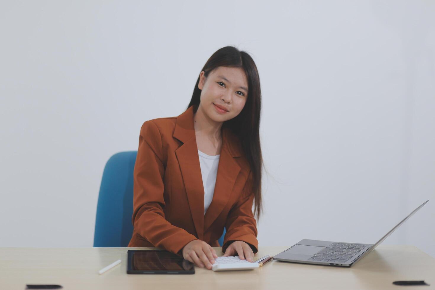 Happy young asian businesswoman sitting on her workplace in the office. Young woman working at laptop in the office. photo