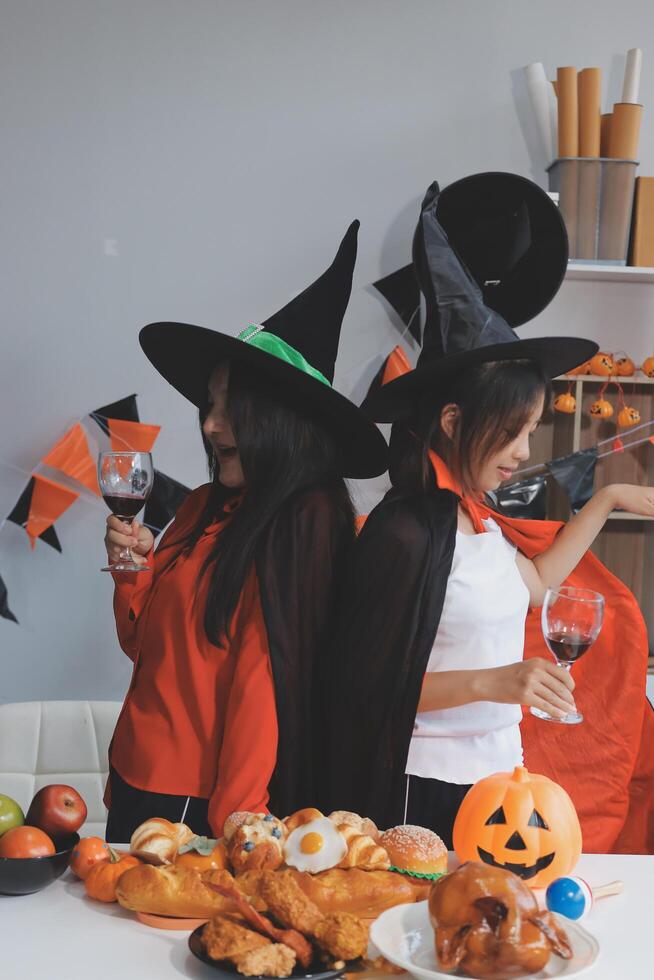 friendship, holiday and people concept - group of happy smiling friends in halloween costumes of vampire, devil, witch and cheetah at home party photo