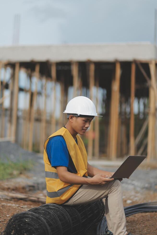 Asian man architect holds blueprint with skyscraper background, Asian male architect builder engineer design working planning confident outdoors in construction site. photo