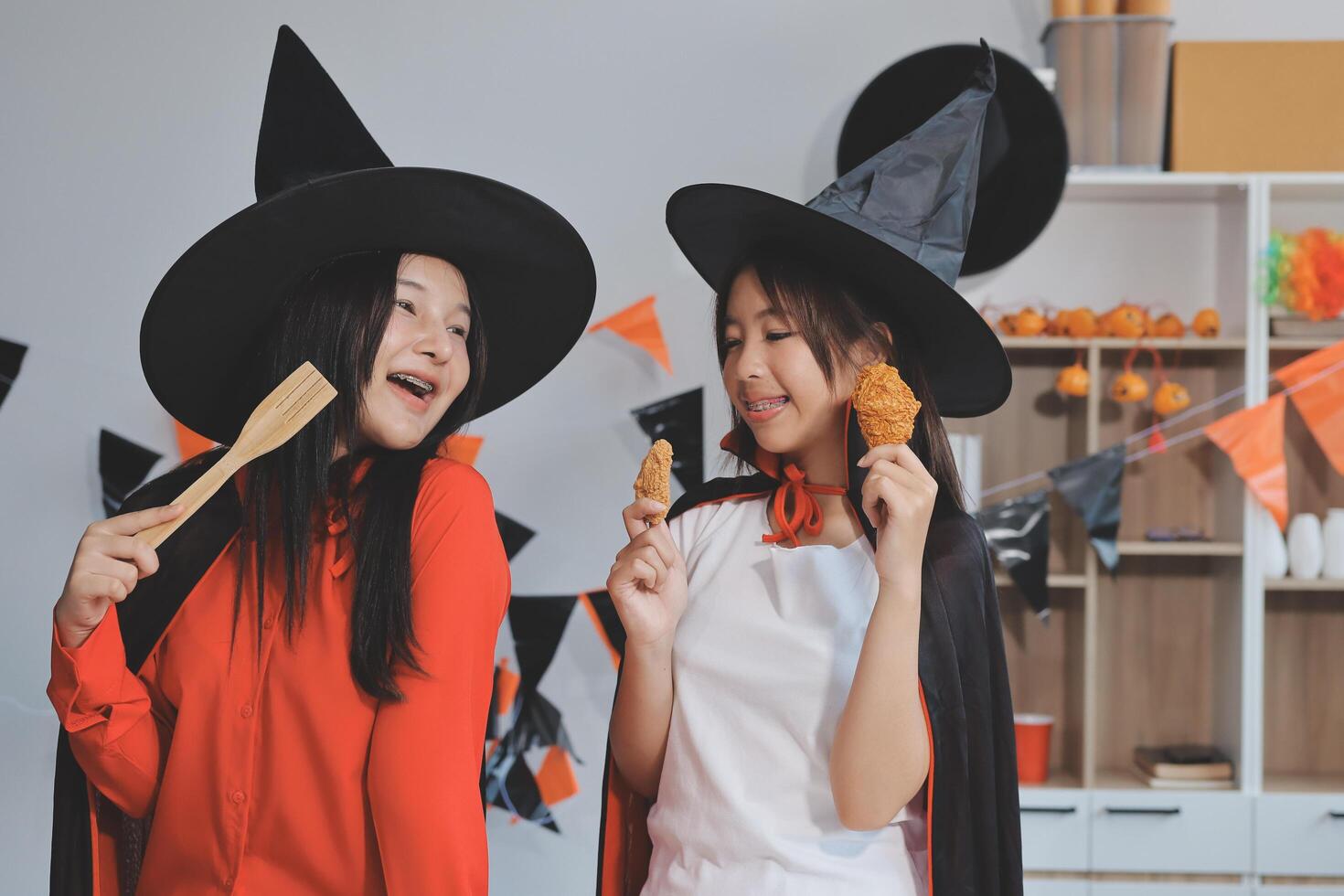 friendship, holiday and people concept - group of happy smiling friends in halloween costumes of vampire, devil, witch and cheetah at home party photo