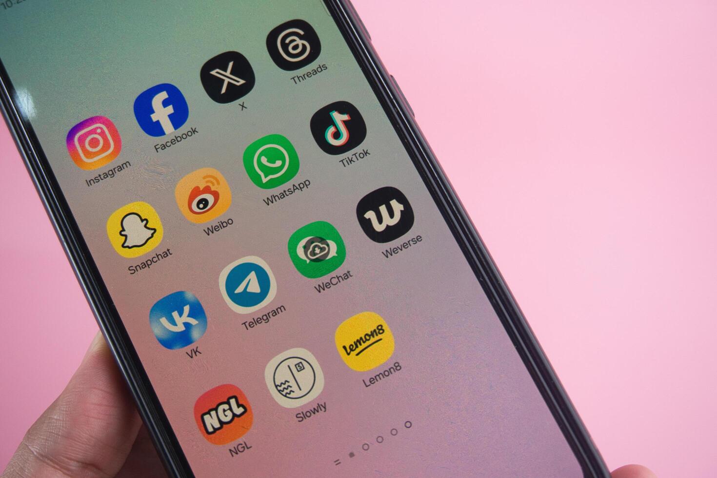 Close-Up of Smartphone Displaying Popular Social Media Applications on Pink Background photo