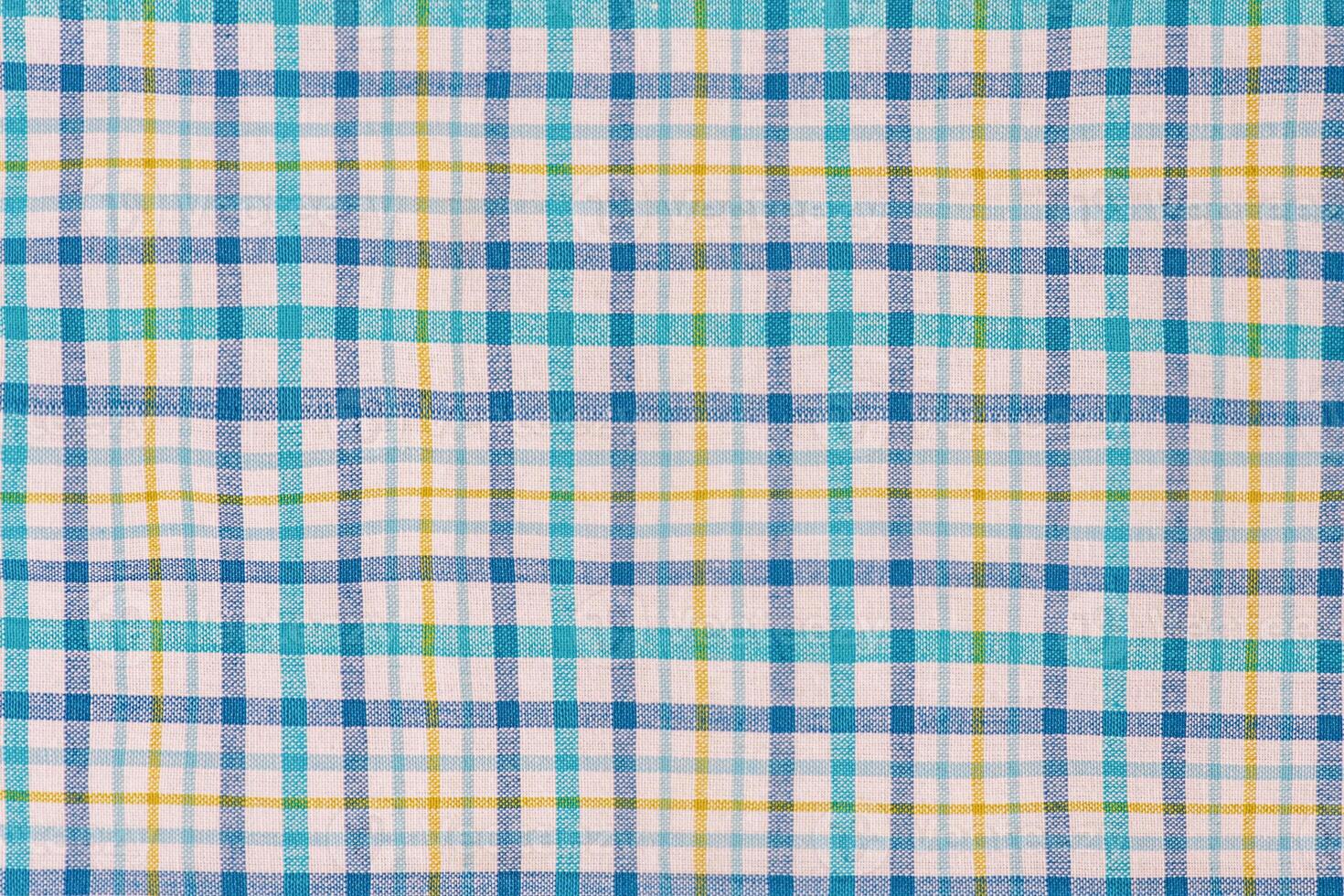 Checkered fabric in blue, white and yellow as a background. photo