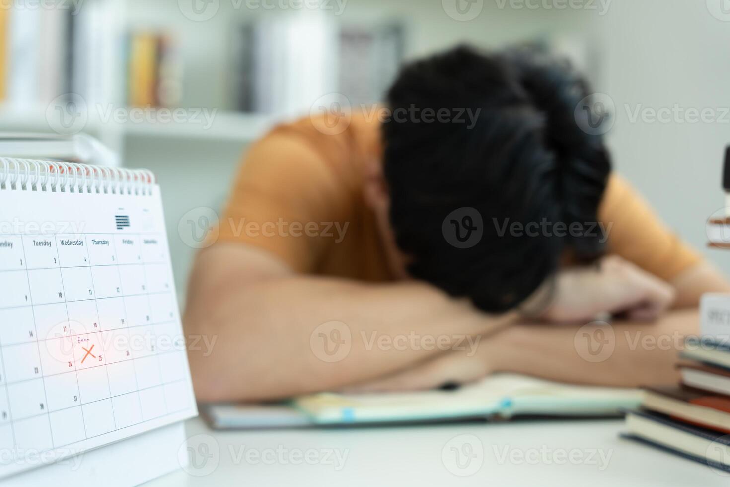 Asian student man have anxiety because of exams, male prepare for test and learning lessons in the library. stress, despair, haste, misunderstanding reading, discouraged, expectation, knowledge, tired photo