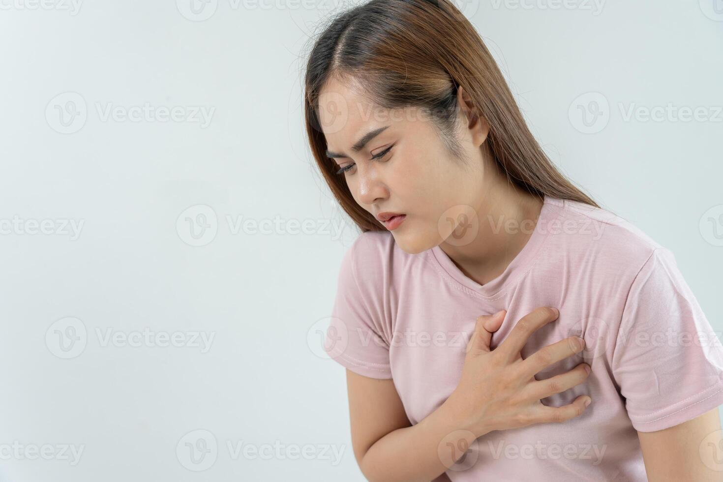 hand hold chest with heart attack symptoms, asian woman have chest pain caused by heart disease, leak, dilatation, enlarged coronary heart, press on the chest with a painful expression photo