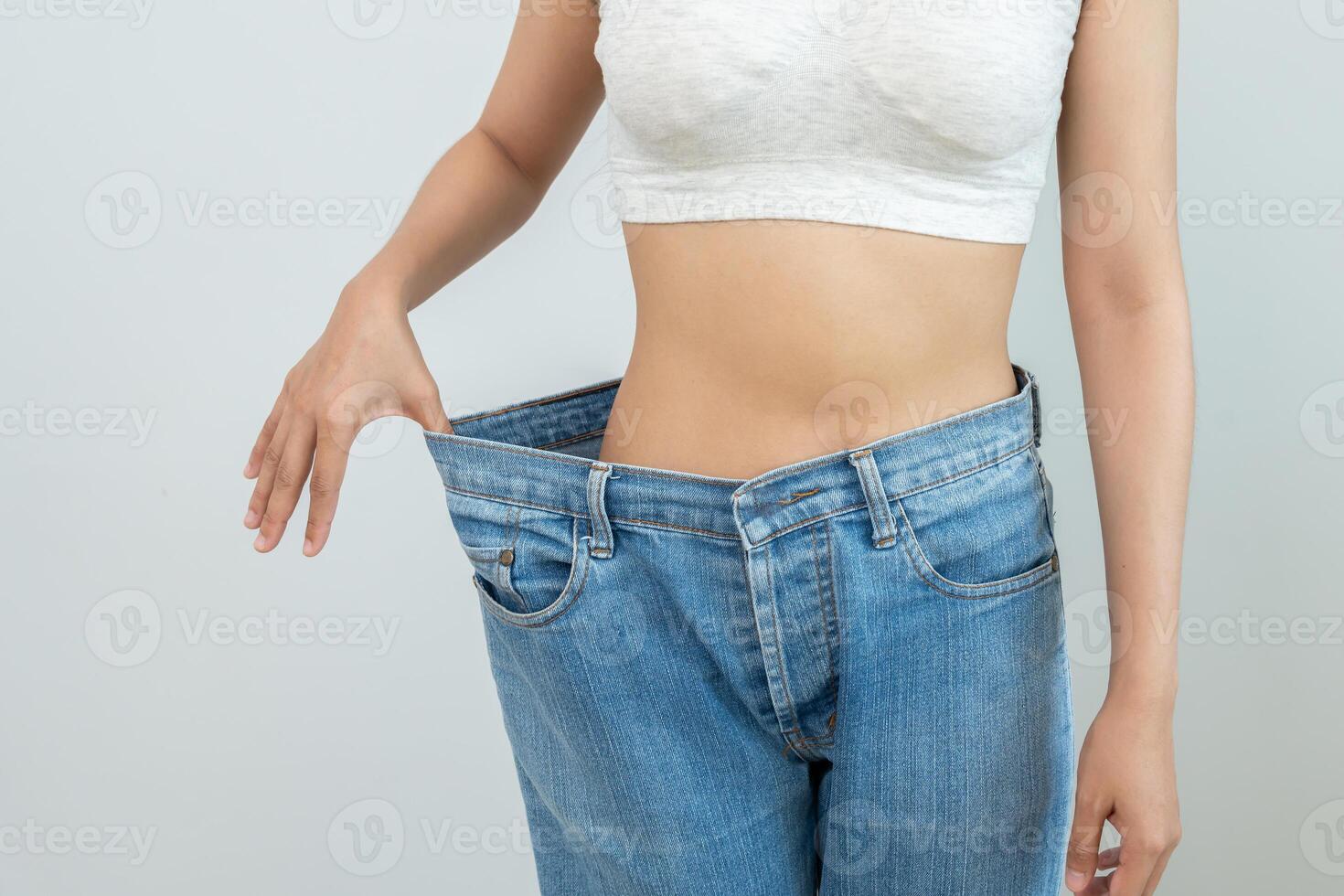 Women showing results of diet. Beautiful shape. female have a reduced waist size after under going a weight loss corse. can not wear jeans due to weight loss. balance, control, routines, exercise. photo