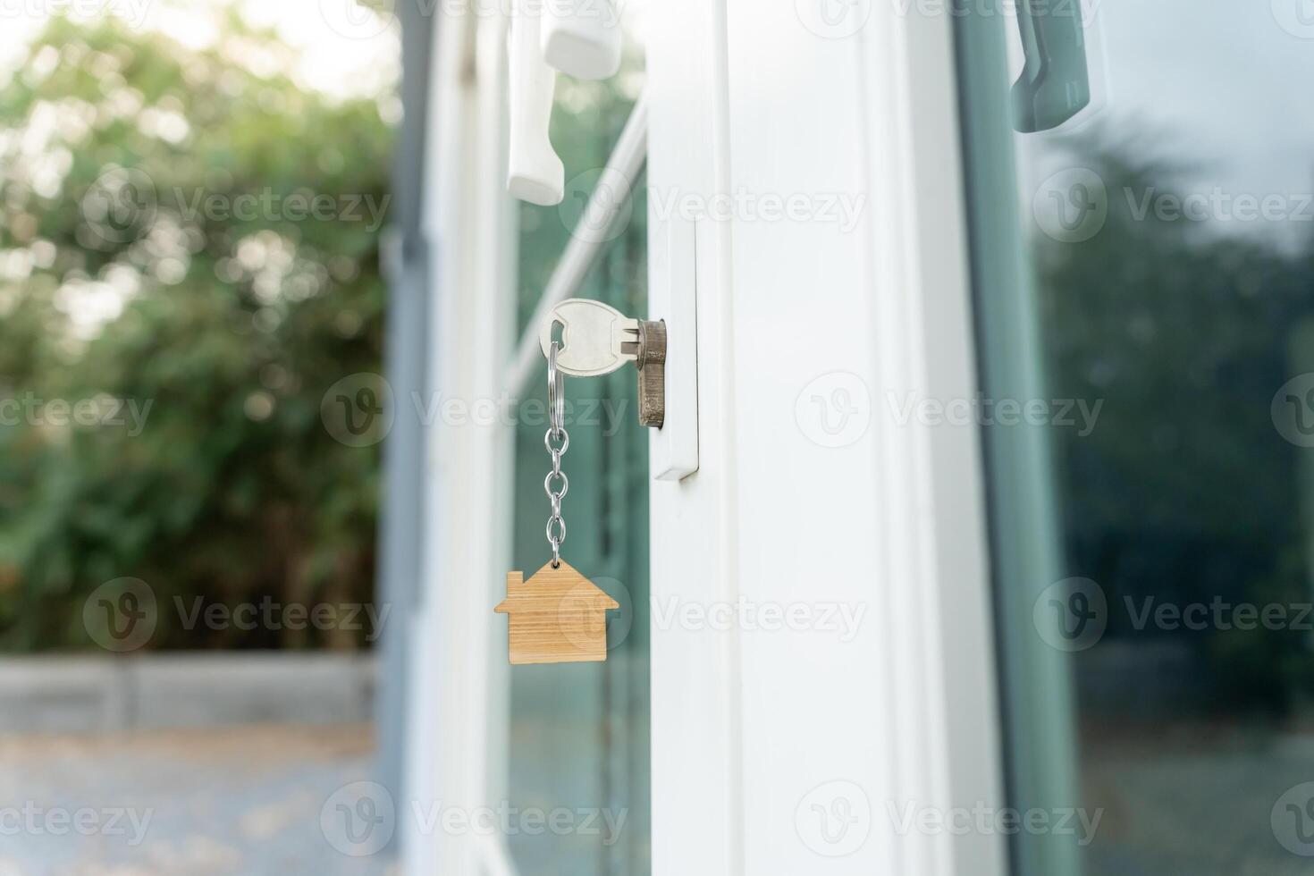 Landlord key for unlocking house is plugged into the door. Second hand house for rent and sale. keychain is blowing in the wind. mortgage for new home, buy, sell, renovate, investment, owner, estate photo