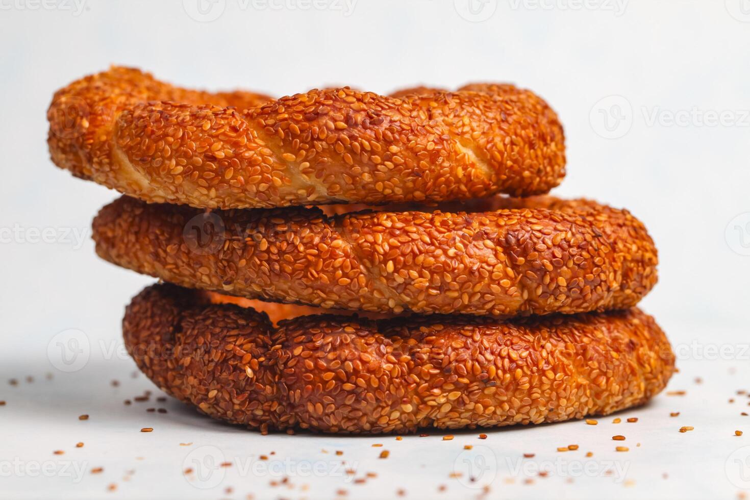 Freshly baked sesame rings stacked on a light background photo
