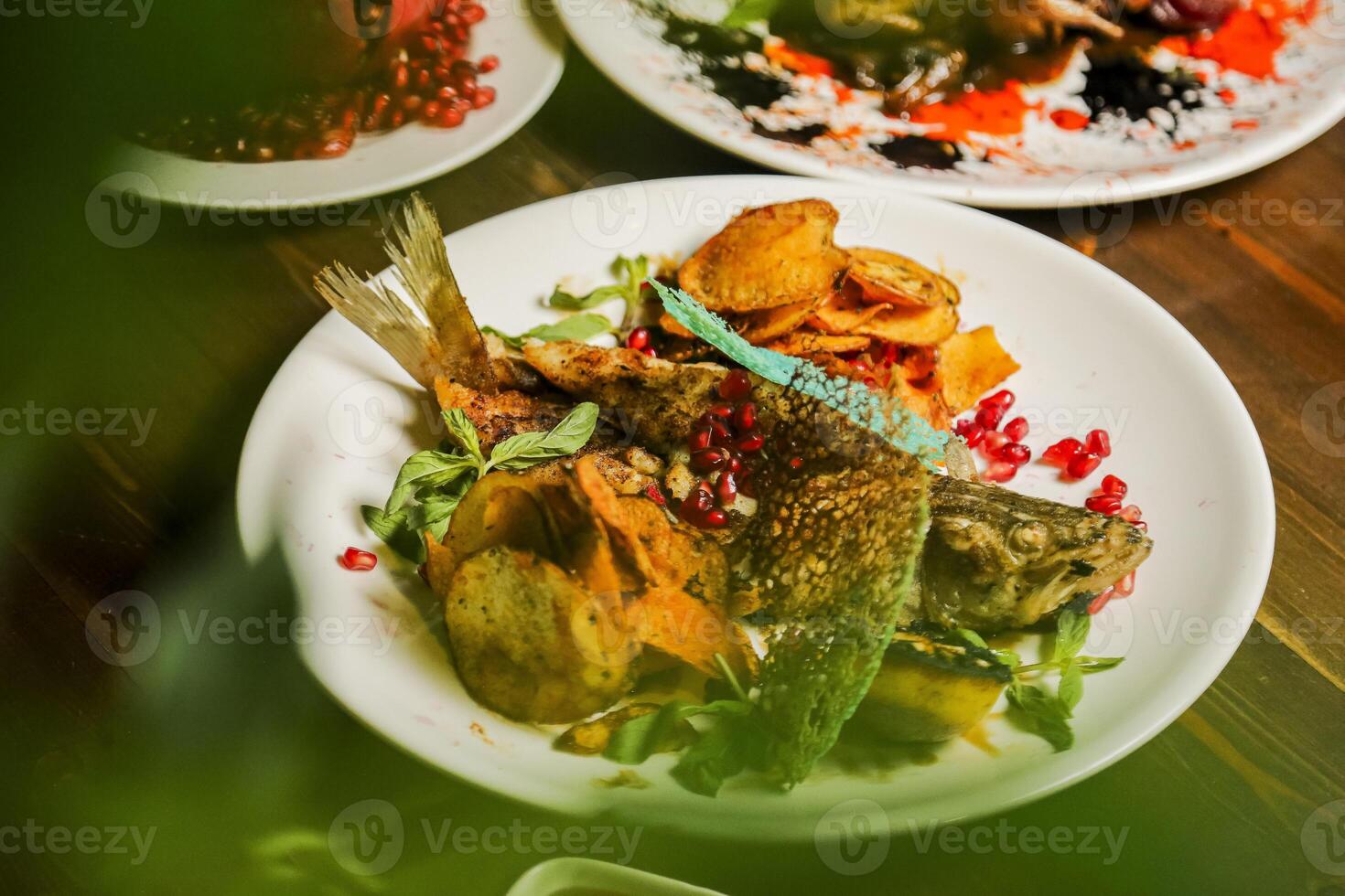 Delicious grilled fish served on a plate with vibrant garnishes photo