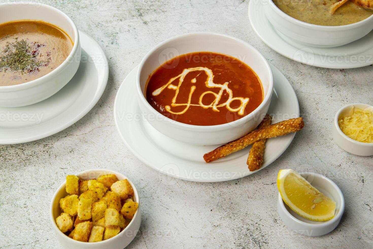 Delicious bowls of savory soups with toppings and sides on the table photo