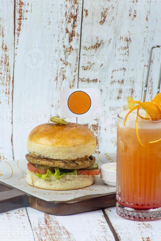 Delicious burger and refreshing drink served on a wooden tray photo