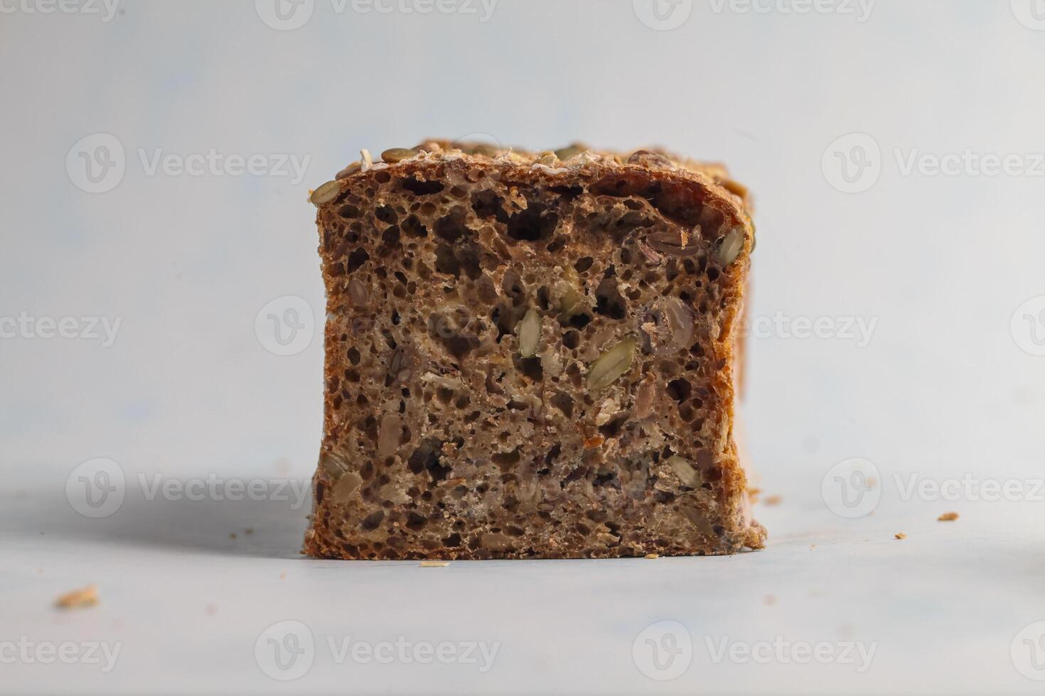 Freshly baked whole grain bread with seeds on a light background photo