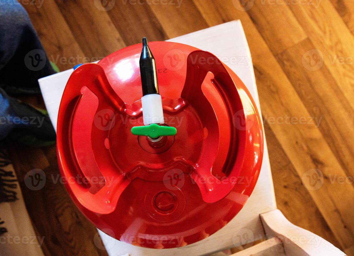 Closeup top view of a red portable helium gas tank, used for quick balloon inflating at parties, celebrations, weddings, and special events. Essential for festive gatherings and birthday decorations. photo