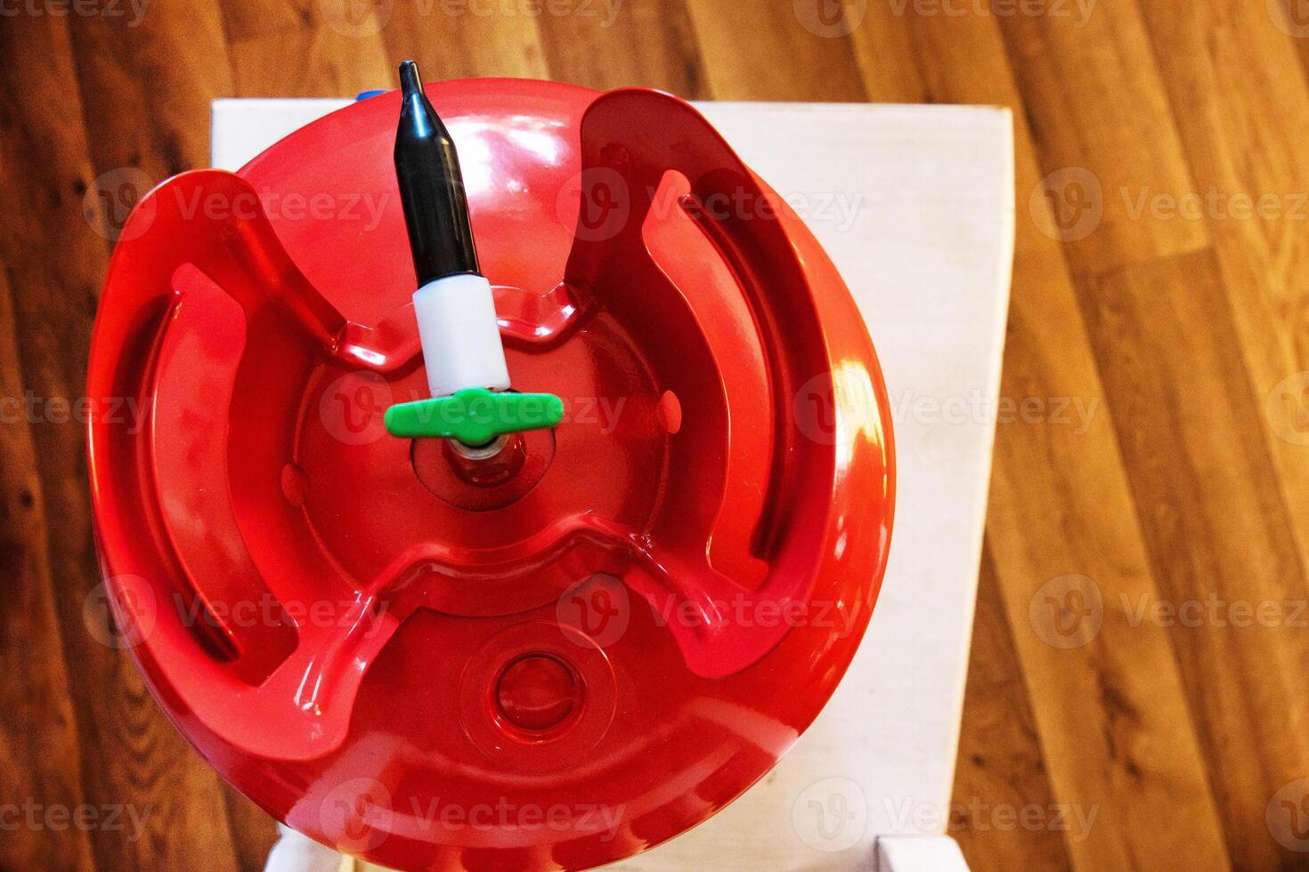 Closeup top view of a red portable helium gas tank, used for quick balloon inflating at parties, celebrations, weddings, and special events. Essential for festive gatherings and birthday decorations photo