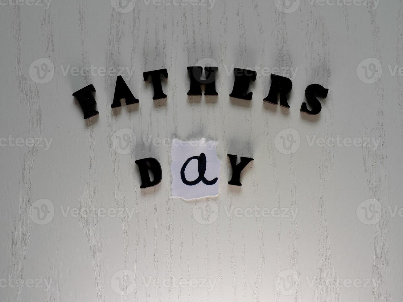 Lettering father in black letters on grey background on father's day close-up photo