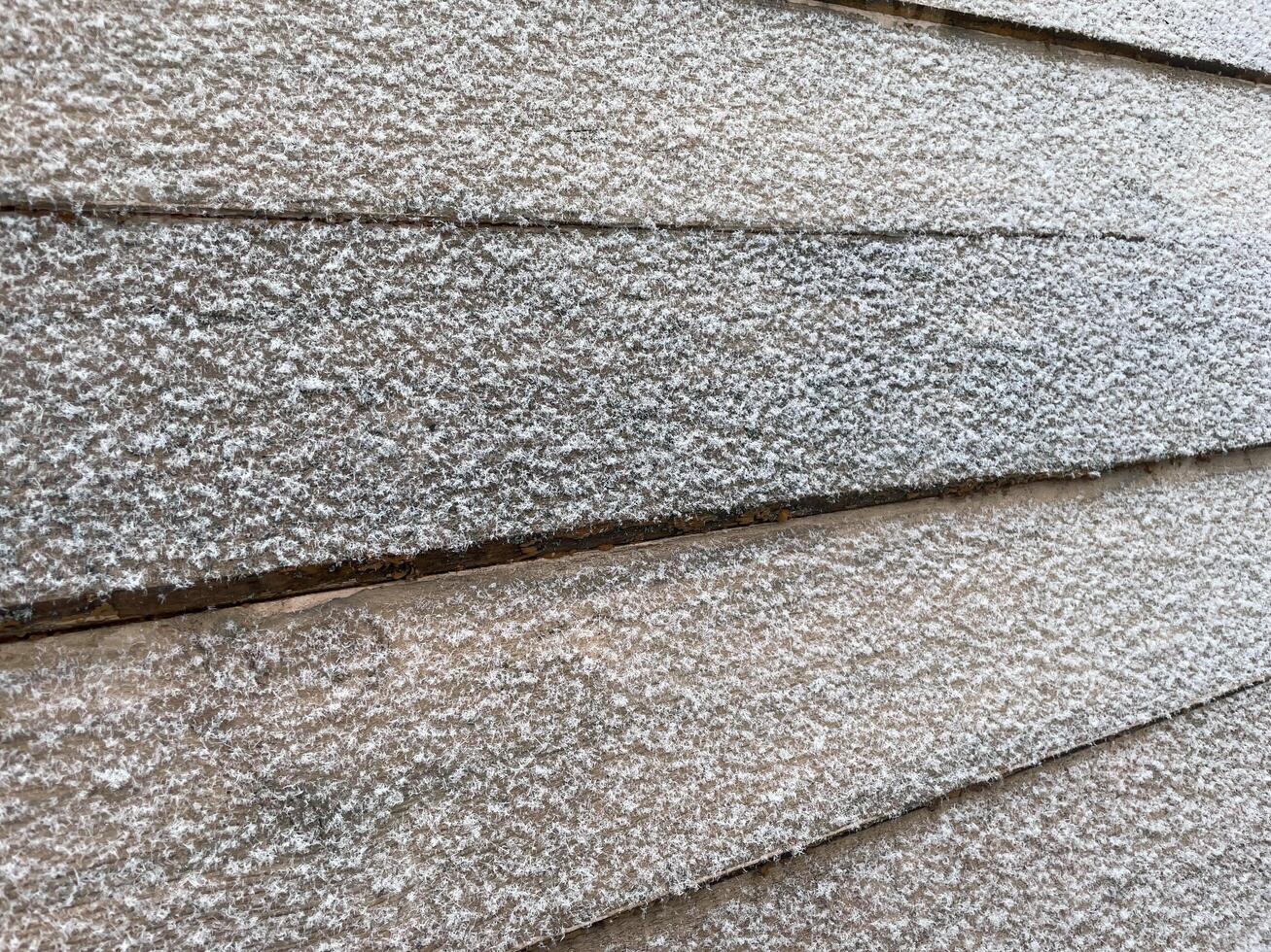 Snow resting gently on painted wooden planks photo