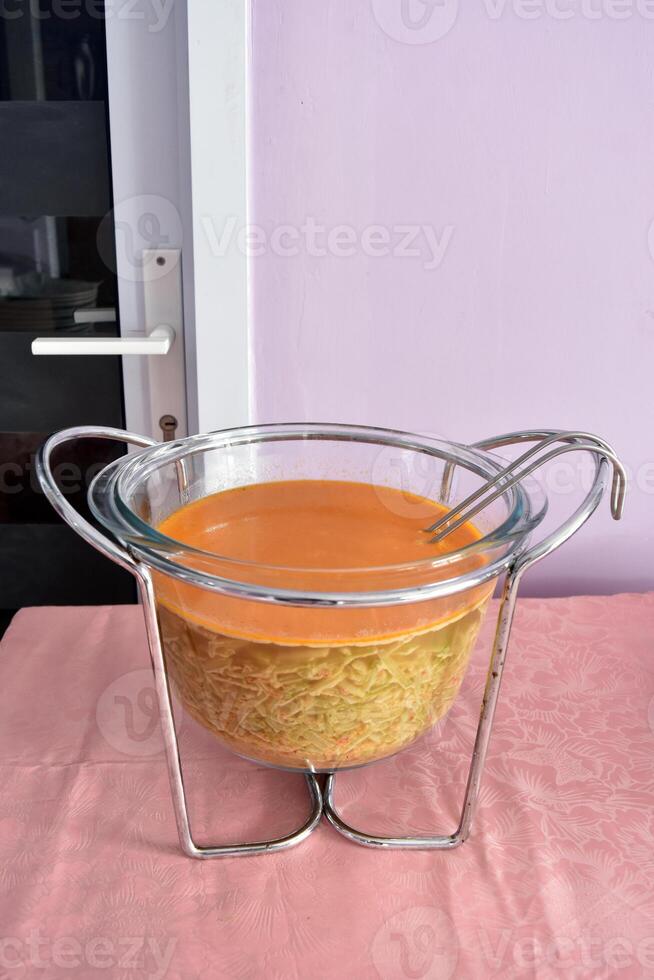 A jar of Sayur lodeh, a popular Indonesian vegetable soup prepared from vegetables cooked in coconut milk, and is most often associated with Javanese cuisine photo