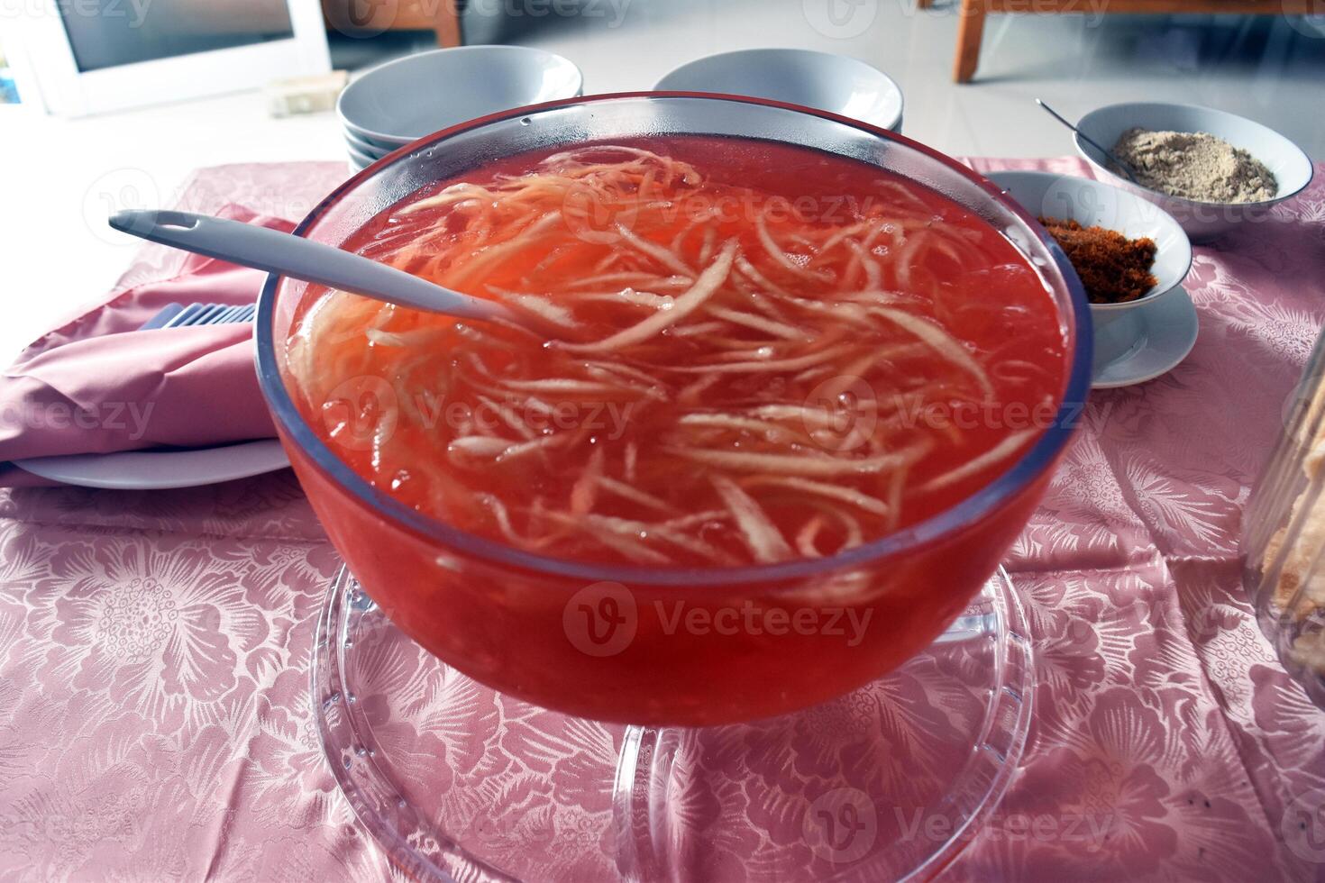 High angle view of a jar of Es blewah, a refreshing drink that is popular in Indonesia, made from grated cantaloupe, syrup, ice cubes, condensed milk, and other ingredients. photo
