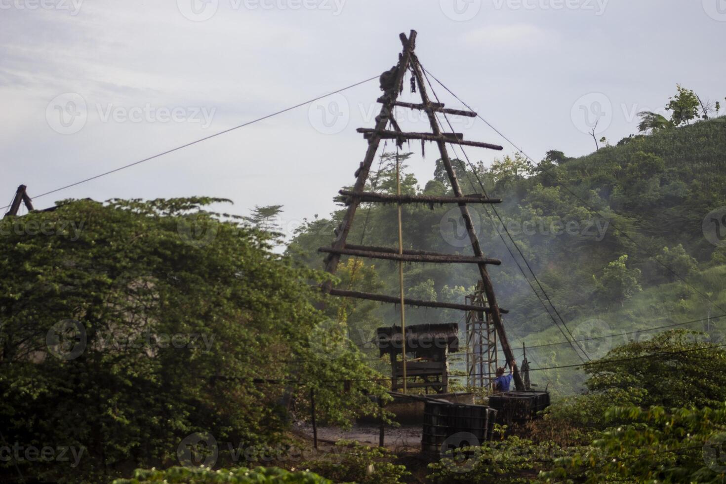 Traditional pulley pole wooden tripod used to extract oil from old oil mining wells in Wonocolo, Bojonegoro, East Java, Indonesia. photo