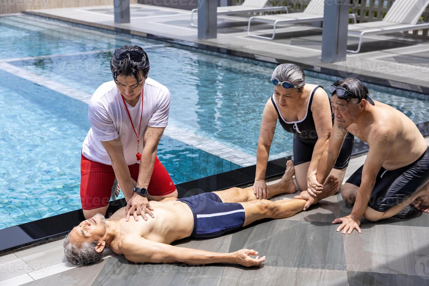 Life guard is doing CPR to the drowning asian senior man at sport club with the family support for accident and emergency medical procedure service and life insurance photo
