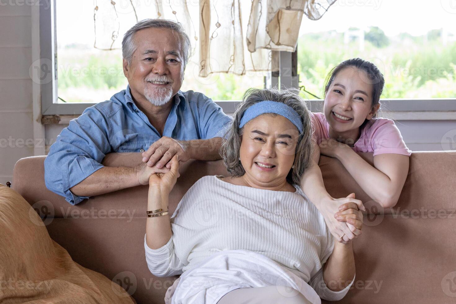 Asian family with senior parents and middle age daughter sitting together in the living room on cozy sofa couch for retirement and happy life photo
