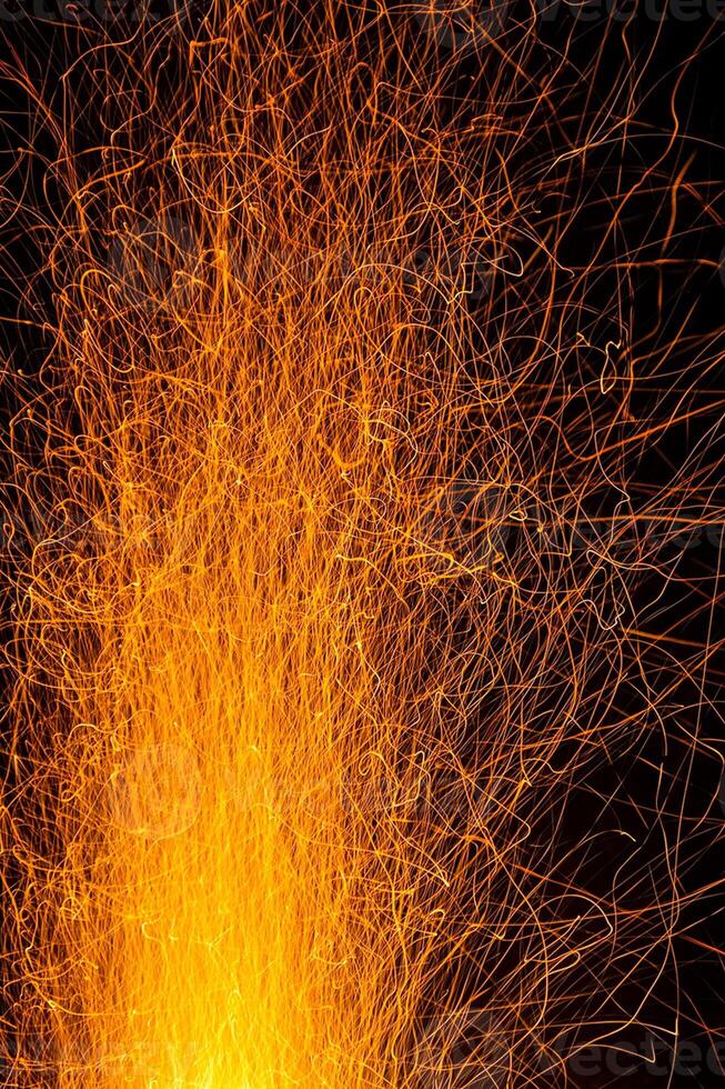 Sparks from a fire against dark night. Bonfire photo