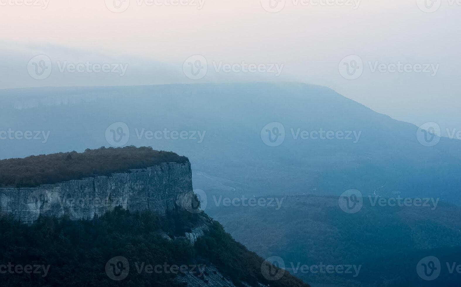 Dawn in the mountains of Crimea. light haze of mist over the mountains and rays of the sun through the clouds. photo