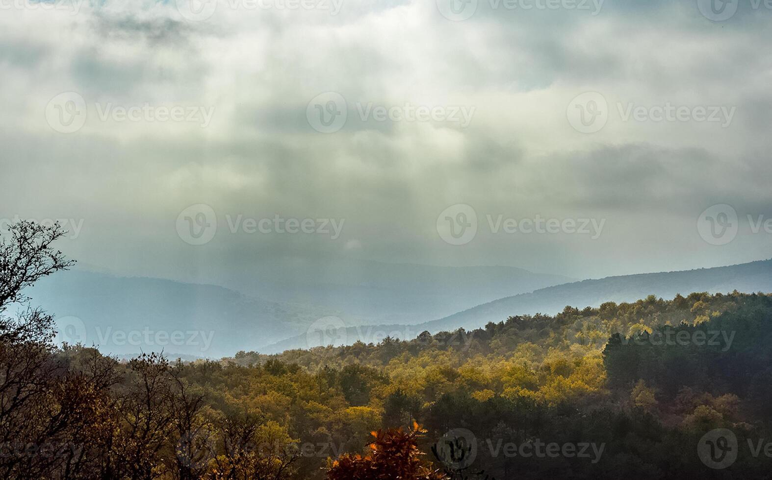 Dawn in the mountains of Crimea. light haze of mist over the mountains and rays of the sun through the clouds. photo
