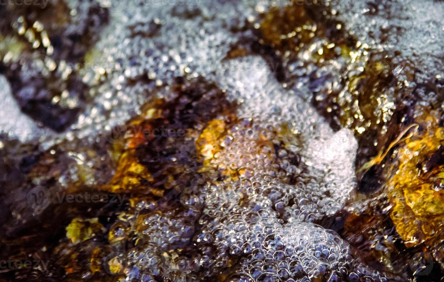 Bubbles on the water in a creek. water flows from the creek. photo