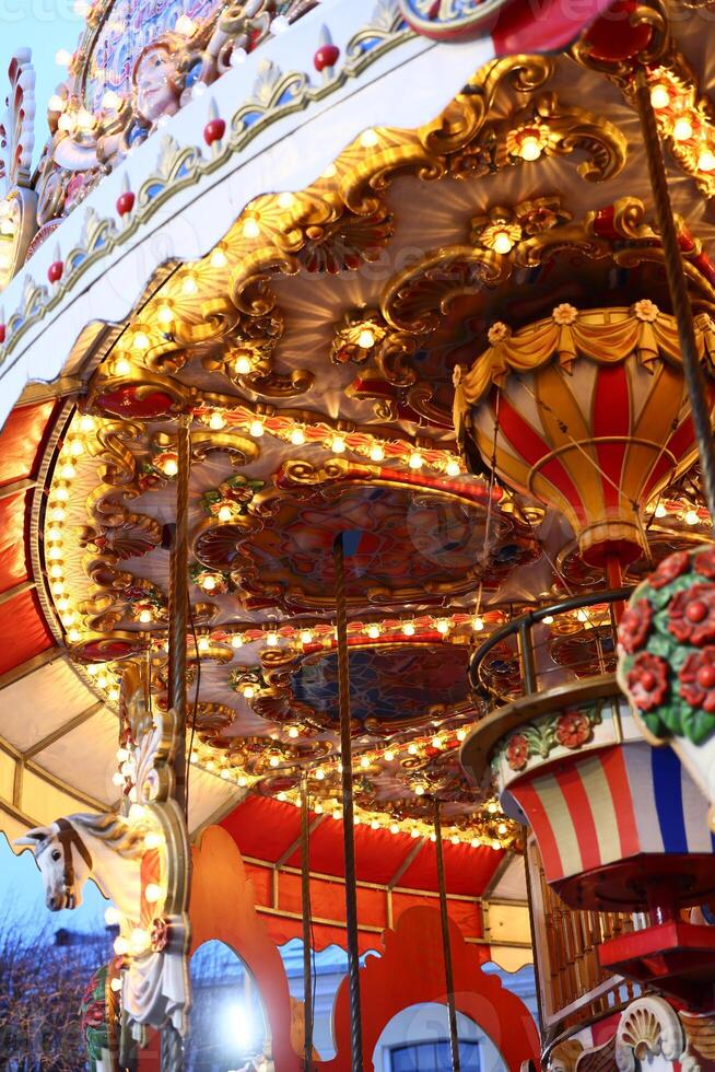 A Beautifully Vibrant Fairground Carousel Bathed in Colorful, EyeCatching Lights photo