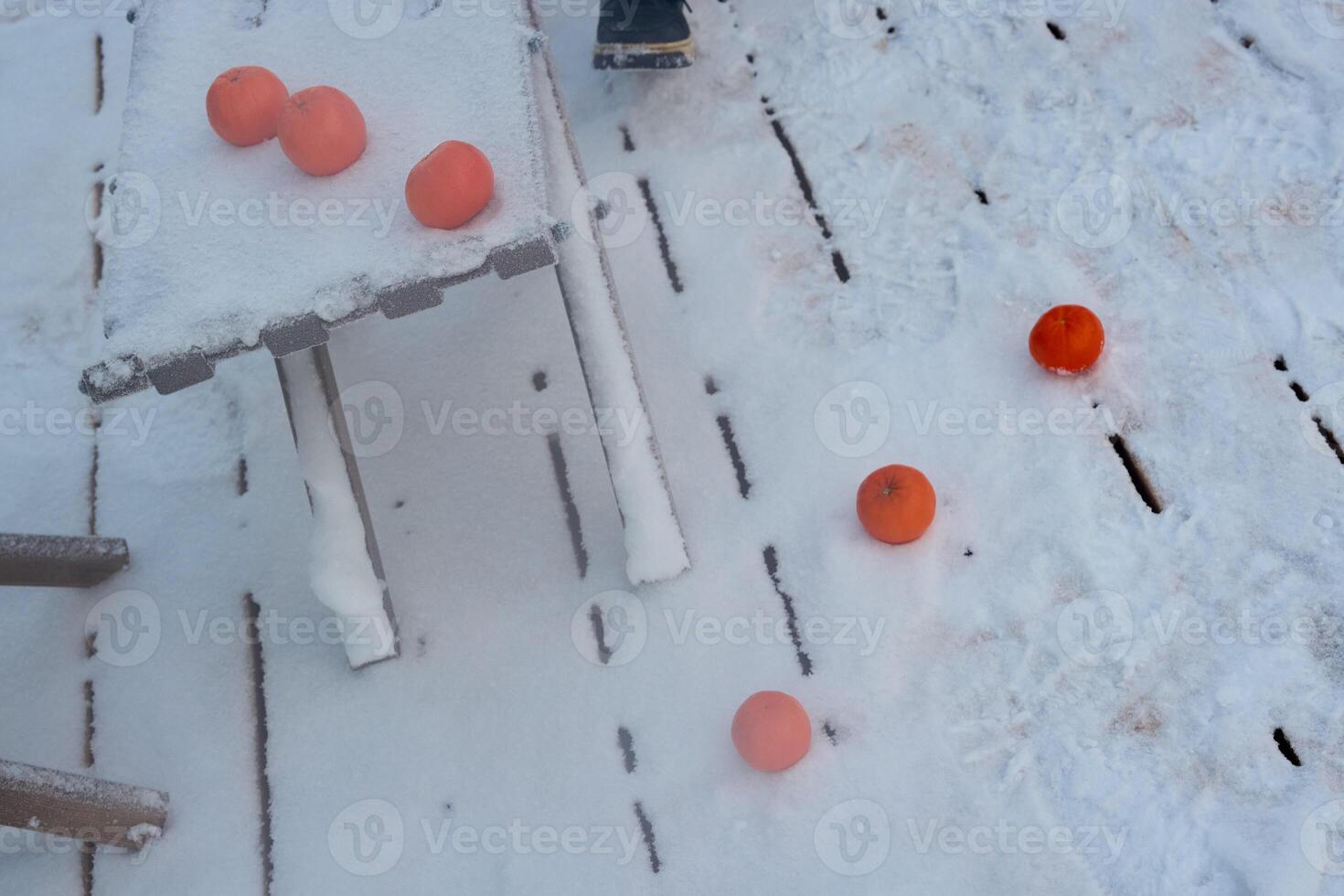 Bright orange balls scattered across a snowy surface create a vibrant and joyful scene photo
